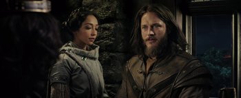 Movie still from “Warcraft” (2016), directed by Duncan Jones – A man and a woman standing next to each other in front of a stone wall; Medium shot, Over the shoulder angle
