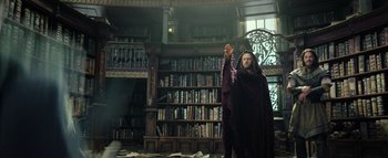 Movie still from “Warcraft” (2016), directed by Duncan Jones – A man standing in front of a book shelf; Medium shot, Low angle