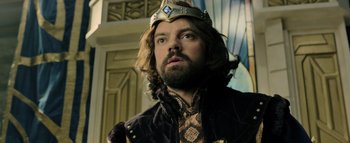 Movie still from “Warcraft” (2016), directed by Duncan Jones – A man with a beard wearing a gold crown; Close Up shot, Low angle