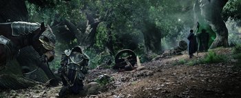 Movie still from “Warcraft” (2016), directed by Duncan Jones – A man in a black suit standing next to a tree; Extreme Wide shot, High angle