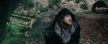Movie still from “Warcraft” (2016), directed by Duncan Jones – A man with a long beard wearing a hooded jacket; Medium shot, High angle