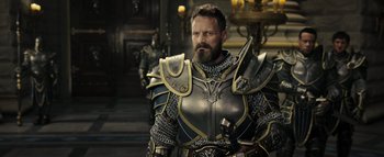 Movie still from “Warcraft” (2016), directed by Duncan Jones – A man dressed as a medieval knight in a room; Medium shot, Over the shoulder angle