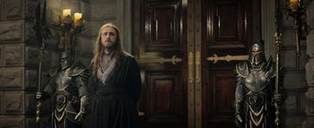 Movie still from “Warcraft” (2016), directed by Duncan Jones – A man standing in front of a wooden door; Medium shot, Over the shoulder angle