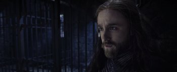 Movie still from “Warcraft” (2016), directed by Duncan Jones – A man with long black hair and a long beard; Close Up shot, Low angle