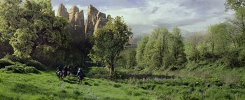 Movie still from “Warcraft” (2016), directed by Duncan Jones – Two people riding horses through a lush green field; Extreme Wide shot, Low angle