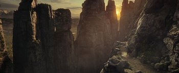 Movie still from “Warcraft” (2016), directed by Duncan Jones – The sun is setting over a mountain range; Extreme Wide shot, High angle