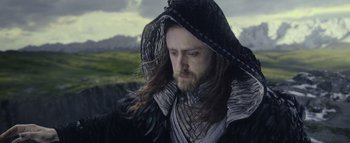Movie still from “Warcraft” (2016), directed by Duncan Jones – A man with long hair and a beard wearing a hood; Close Up shot, Over the shoulder angle