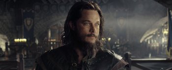 Movie still from “Warcraft” (2016), directed by Duncan Jones – A person with long hair and a beard; Close Up shot, Over the shoulder angle