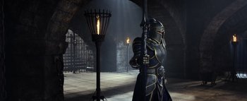 Movie still from “Warcraft” (2016), directed by Duncan Jones – A man holding a sword in a room; Wide shot, Low angle