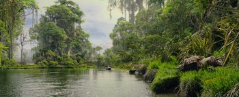 Movie still from “Warcraft” (2016), directed by Duncan Jones – A body of water surrounded by green trees and bushes; Extreme Wide shot, Low angle