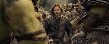 Movie still from “Warcraft” (2016), directed by Duncan Jones – A man standing in front of a bunch of other people; Medium shot, Over the shoulder angle