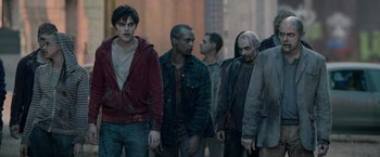 Movie still from “Warm Bodies” (2013), directed by Jonathan Levine – A group of zombies walking down a street; Medium shot, Over the shoulder angle
