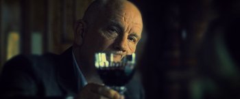 Movie still from “Warm Bodies” (2013), directed by Jonathan Levine – An older man holding a glass of red wine; Close Up shot, Low angle