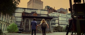 Movie still from “Warm Bodies” (2013), directed by Jonathan Levine – A man and a woman holding hands in front of a building; Wide shot, Over the shoulder angle