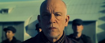 Movie still from “Warm Bodies” (2013), directed by Jonathan Levine – An older man with a shaved head is looking at the camera; Close Up shot, Low angle