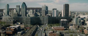 Movie still from “Warm Bodies” (2013), directed by Jonathan Levine – An aerial view of a city with a large wall in the middle of it; Extreme Wide shot, High angle