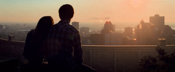 Movie still from “Warm Bodies” (2013), directed by Jonathan Levine – A man and a woman looking out over a city at sunset; Wide shot, Over the shoulder angle