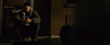 Movie still from “Warrior” (2011), directed by Gavin O'Connor – A man sitting on a bench in the dark; Medium shot, Low angle