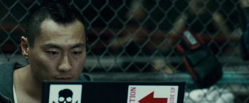 Movie still from “Warrior” (2011), directed by Gavin O'Connor – A man sitting in front of a computer screen; Close Up shot, Over the shoulder angle
