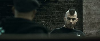 Movie still from “Warrior” (2011), directed by Gavin O'Connor – A man with a bald head is looking at another man; Close Up shot, Over the shoulder angle