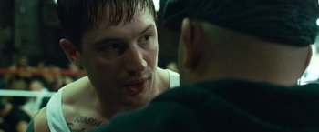 Movie still from “Warrior” (2011), directed by Gavin O'Connor – A man is talking to another man in the dark; Close Up shot, Over the shoulder angle