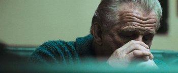 Movie still from “Warrior” (2011), directed by Gavin O'Connor – An older man sitting in a chair with his head resting on a pillow; Close Up shot, High angle