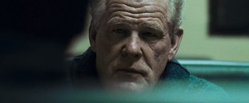 Movie still from “Warrior” (2011), directed by Gavin O'Connor – An older man with a goatee looking at the camera; Close Up shot, Over the shoulder angle