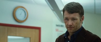 Movie still from “Warrior” (2011), directed by Gavin O'Connor – A person wearing a brown jacket; Close Up shot, Over the shoulder angle