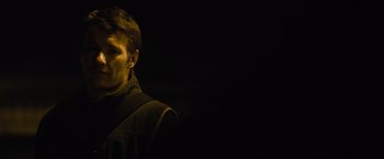 Movie still from “Warrior” (2011), directed by Gavin O'Connor – A man in a black jacket is standing in the dark; Close Up shot, Over the shoulder angle