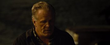 Movie still from “Warrior” (2011), directed by Gavin O'Connor – An older man is looking at something in the dark; Close Up shot, Over the shoulder angle