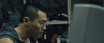 Movie still from “Warrior” (2011), directed by Gavin O'Connor – A person sitting in front of a computer monitor; Close Up shot, Over the shoulder angle