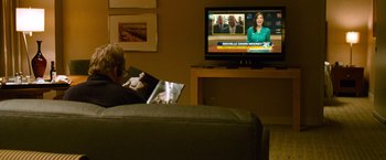 Movie still from “Warrior” (2011), directed by Gavin O'Connor – A man sitting in front of a television; Medium shot, Over the shoulder angle
