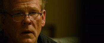 Movie still from “Warrior” (2011), directed by Gavin O'Connor – An older man wearing glasses looking at the camera; Close Up shot, Over the shoulder angle