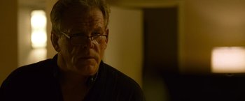Movie still from “Warrior” (2011), directed by Gavin O'Connor – An older man wearing glasses and looking at the camera; Close Up shot, Over the shoulder angle
