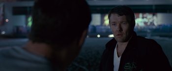 Movie still from “Warrior” (2011), directed by Gavin O'Connor – A man standing next to another man in a parking lot; Close Up shot, Over the shoulder angle