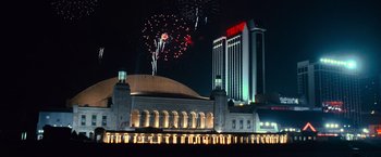 Movie still from “Warrior” (2011), directed by Gavin O'Connor – Fireworks are being lit in the night sky over a large building; Extreme Wide shot, Low angle