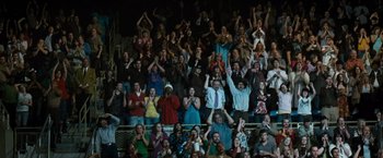 Movie still from “Warrior” (2011), directed by Gavin O'Connor – A group of people standing in the stands at a sporting event; Wide shot, High angle