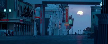 Movie still from “Warrior” (2011), directed by Gavin O'Connor – A street scene with a person walking on the sidewalk; Extreme Wide shot, Low angle