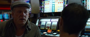 Movie still from “Warrior” (2011), directed by Gavin O'Connor – A man sitting in front of a slot machine; Close Up shot, Over the shoulder angle