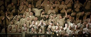 Movie still from “Warrior” (2011), directed by Gavin O'Connor – A large group of men in military uniforms sitting and standing in a stadium; Extreme Wide shot, High angle