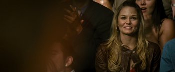 Movie still from “Warrior” (2011), directed by Gavin O'Connor – A beautiful blonde woman smiling at the camera; Close Up shot, Over the shoulder angle