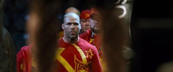 Movie still from “Warrior” (2011), directed by Gavin O'Connor – A group of men standing next to each other wearing red shirts; Medium shot, Over the shoulder angle
