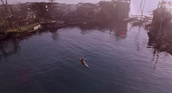 Movie still from “Waterworld” (1995), directed by Kevin Reynolds – A person in a canoe in a body of water; Extreme Wide shot, Overhead angle