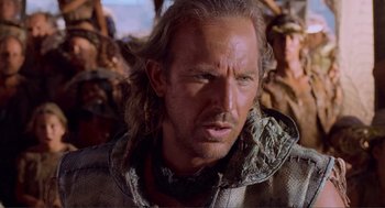 Movie still from “Waterworld” (1995), directed by Kevin Reynolds – A person with long blonde hair; Close Up shot, Over the shoulder angle
