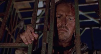 Movie still from “Waterworld” (1995), directed by Kevin Reynolds – A person behind a fence; Close Up shot, Low angle