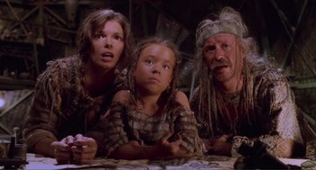 Movie still from “Waterworld” (1995), directed by Kevin Reynolds – A group of people sitting next to each other on the ground; Close Up shot, Low angle