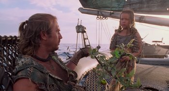 Movie still from “Waterworld” (1995), directed by Kevin Reynolds – A man and a woman on a boat in the water; Medium shot, Low angle
