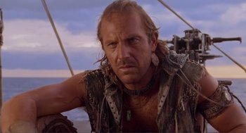 Movie still from “Waterworld” (1995), directed by Kevin Reynolds – A person on a boat with a sky in the background; Close Up shot, Low angle