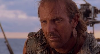 Movie still from “Waterworld” (1995), directed by Kevin Reynolds – A person with a beard; Close Up shot, Over the shoulder angle