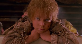 Movie still from “Waterworld” (1995), directed by Kevin Reynolds – A person wearing a costume and looking at the camera; Close Up shot, Low angle